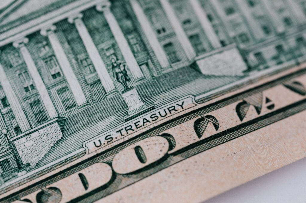 From above ten dollar banknote with inscription and United States treasury building placed on table