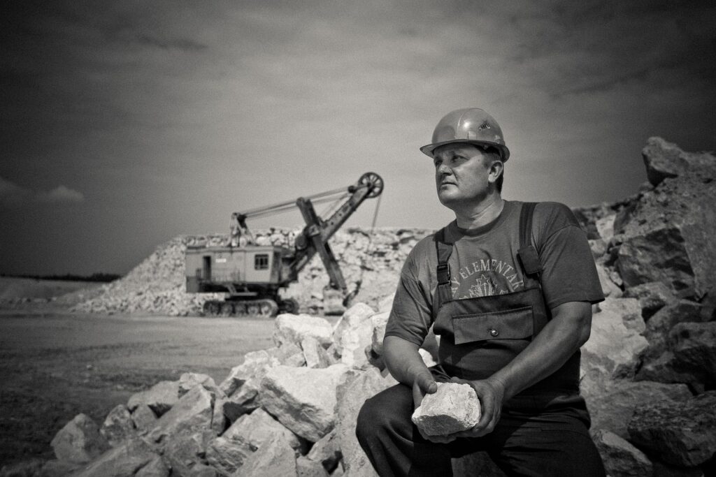 Photo showing adult, construction and hard hat.